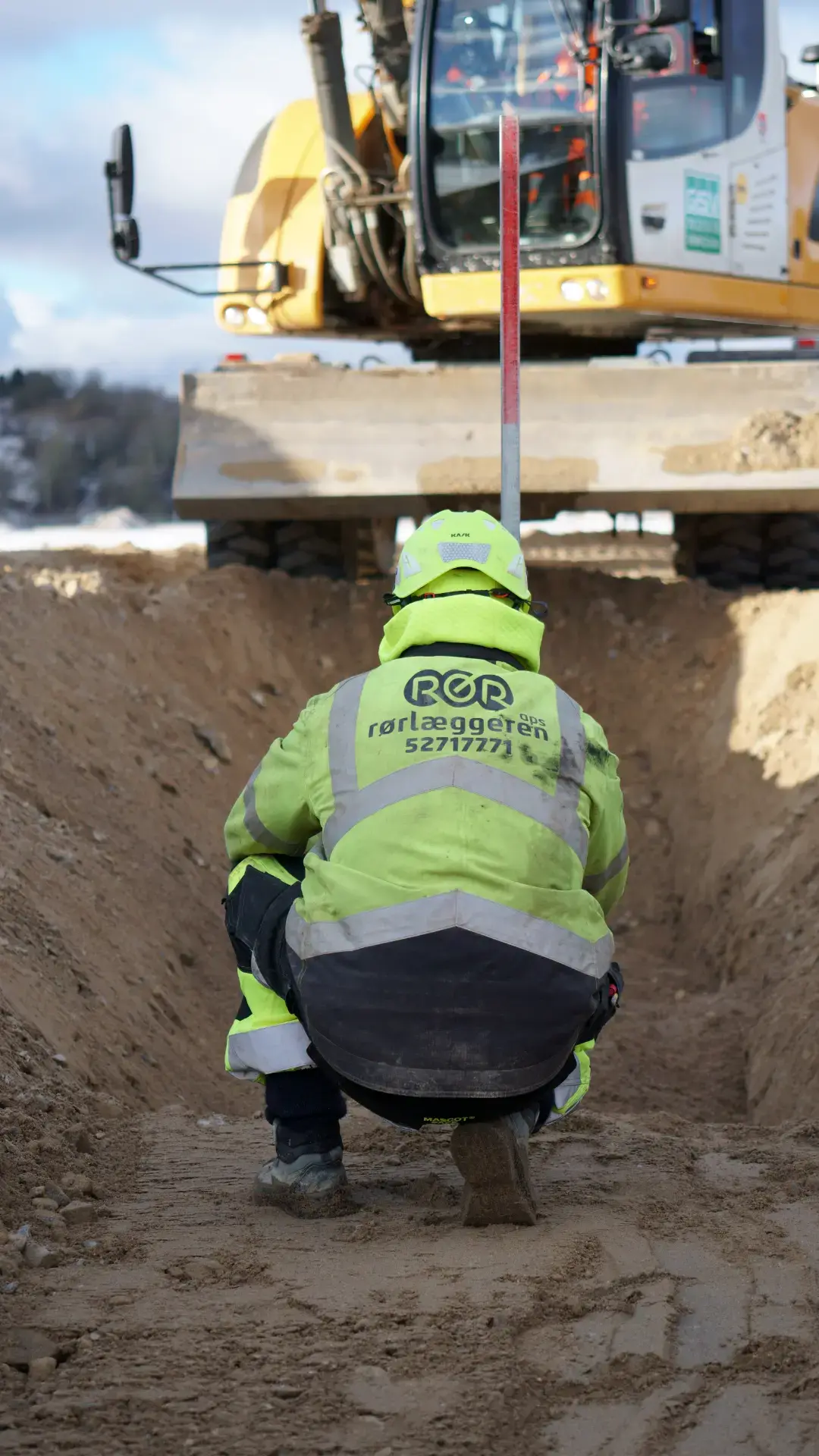 Rørlægger i gravearbejde med maskinudlejning udstyr.