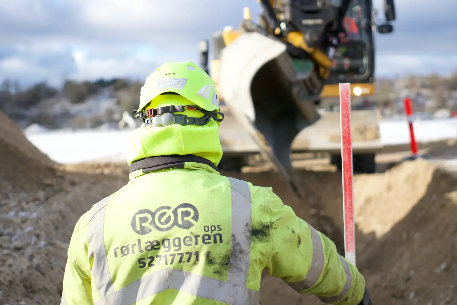 Rørlægger i arbejde med maskinudlejning i udgravning.